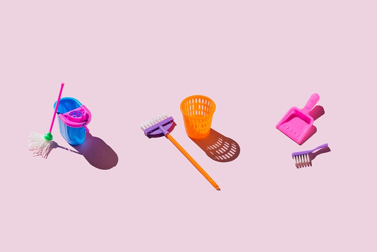 Set de juego de herramientas de limpieza en miniatura de colores sobre fondo rosa